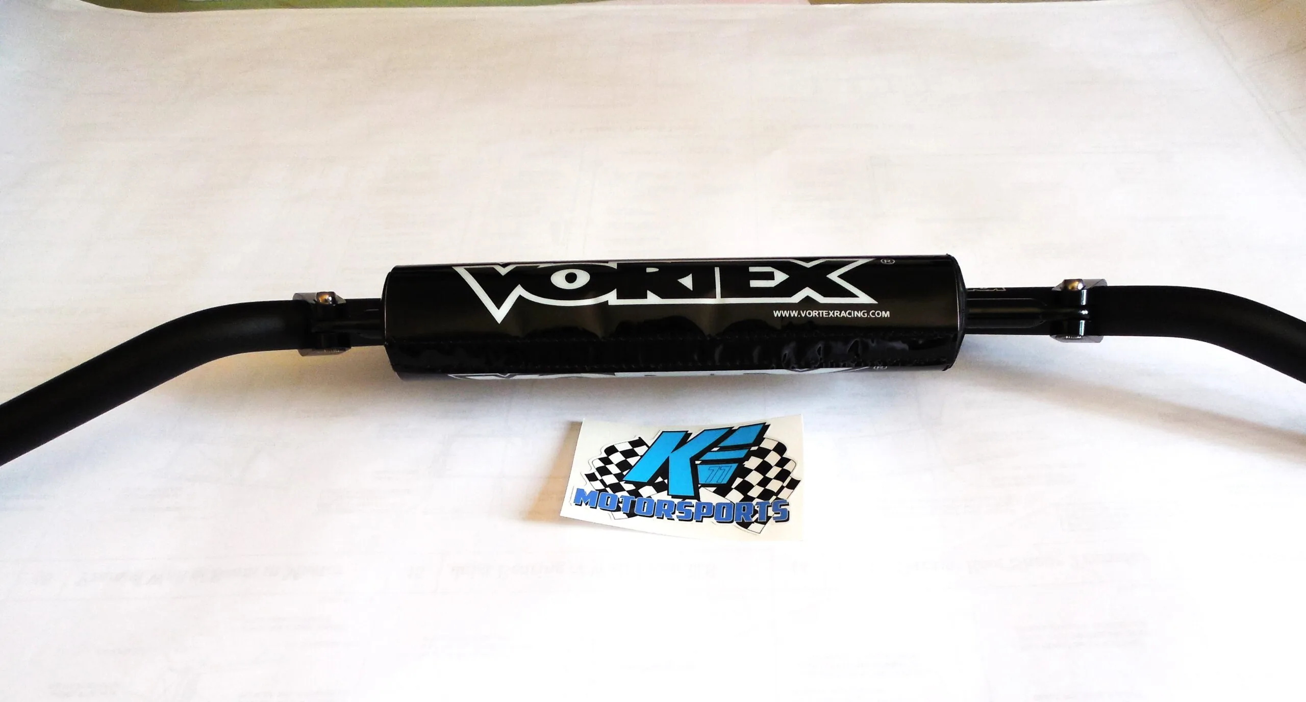 Black Vortex intake tube with checkered flag logo sticker on white surface