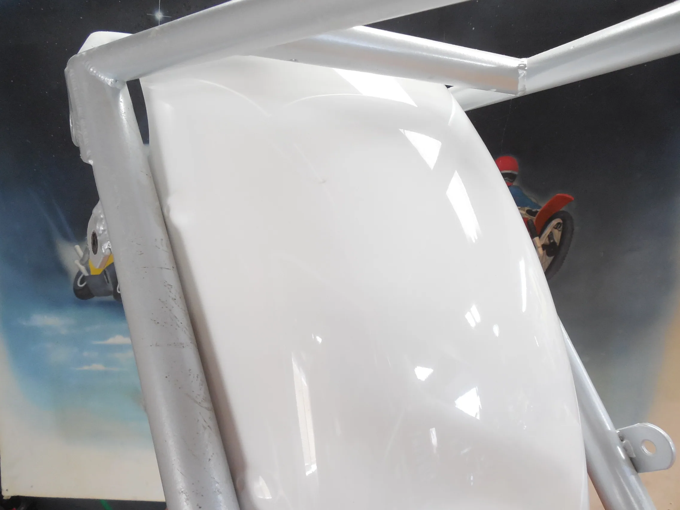 White aircraft fuselage with metallic frame structure and landing gear visible against sky backdrop