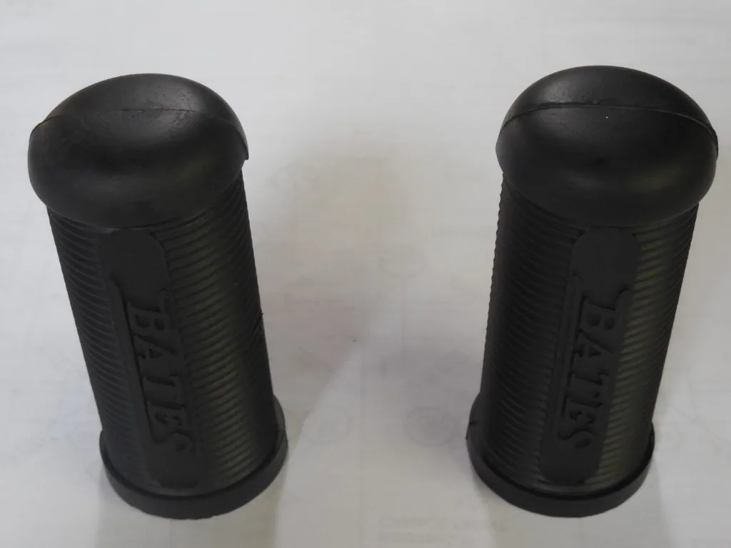 Pair of black rubber motorcycle foot peg covers with textured grip surface and embossed branding