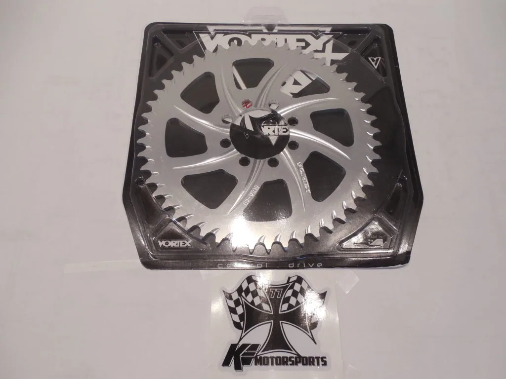 Silver and black circular chainring clock with gear tooth edge design mounted in clear display case
