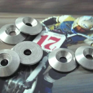 Six metallic washers arranged on a flat-track racing number board with colorful graphics