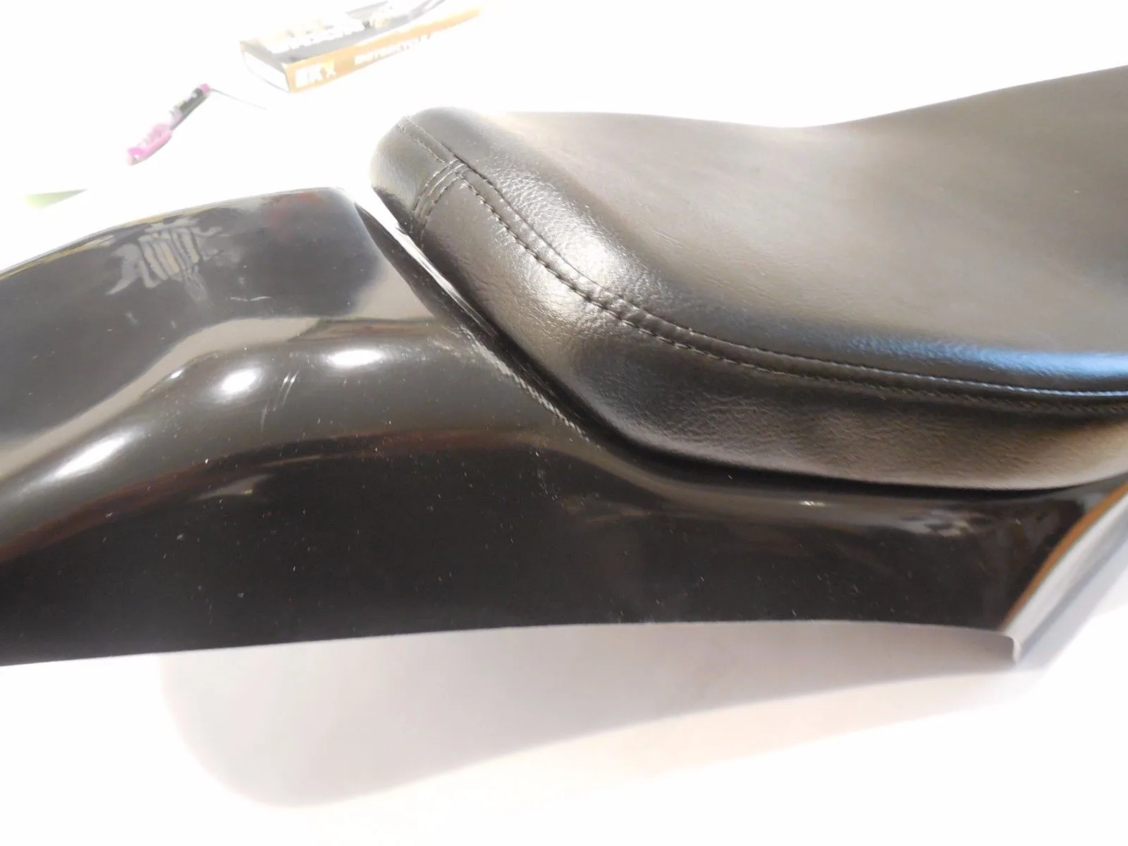 Black leather motorcycle seat with stitched detail on fairing