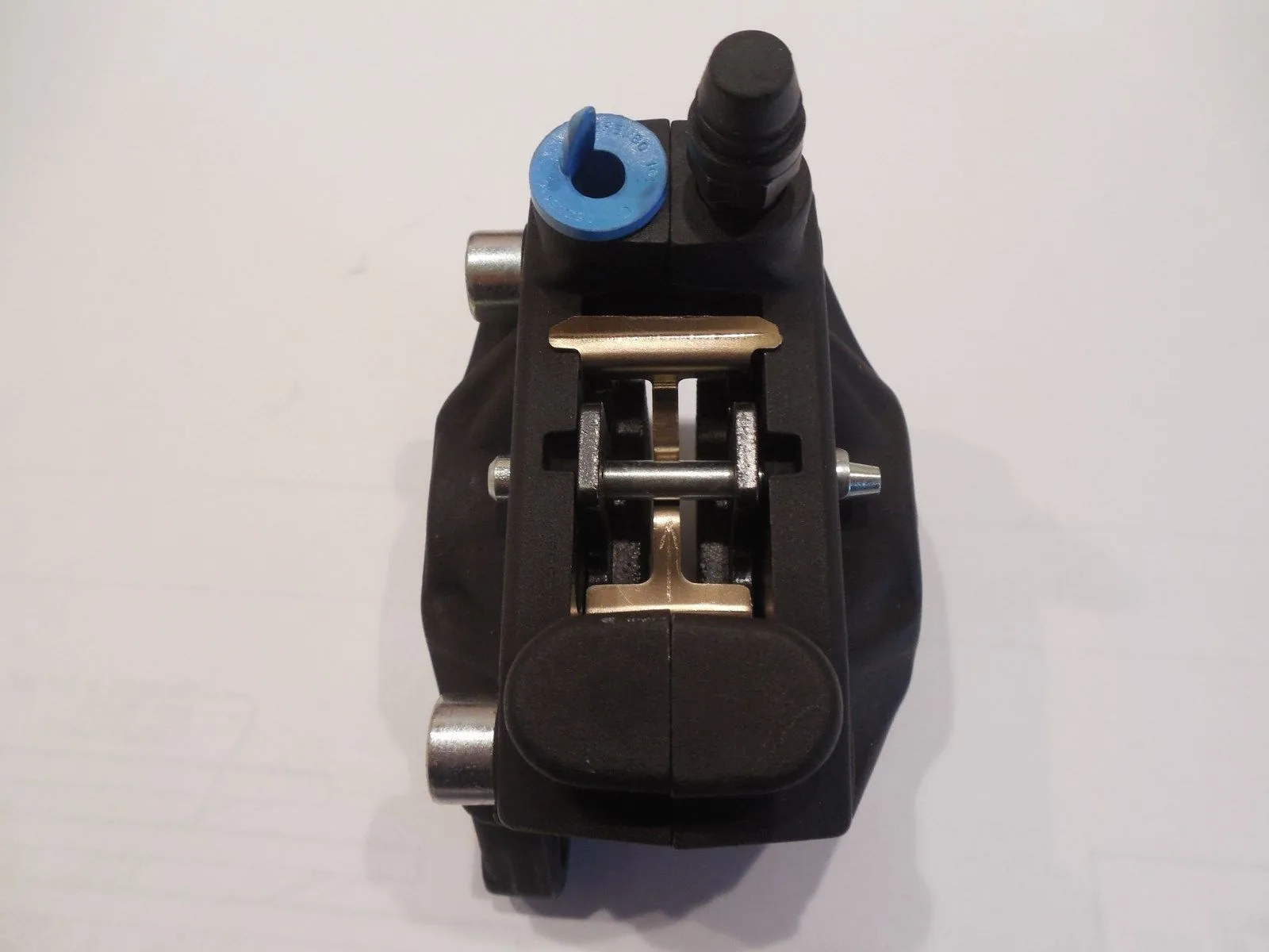 Black bicycle disc brake caliper with blue adjustment ring and metal components on white background