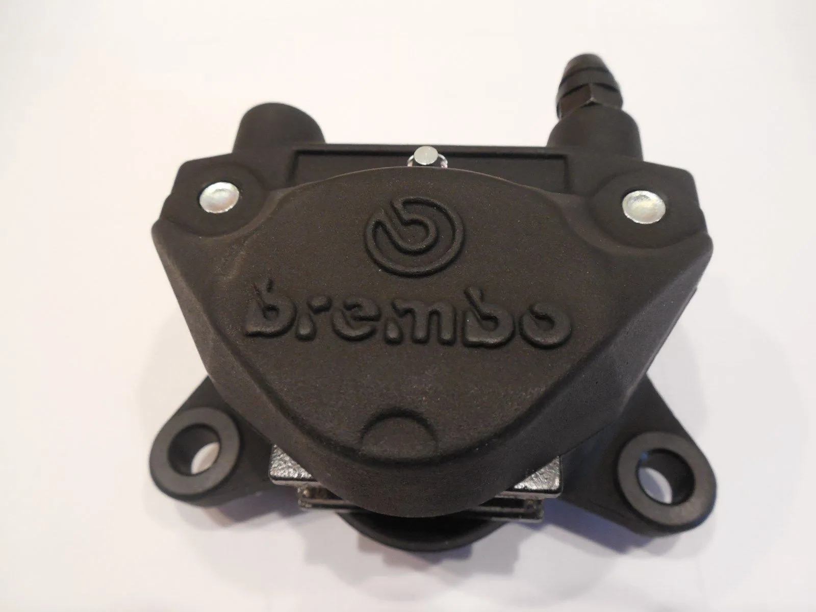 Black brake caliper with embossed logo and mounting bolts against white background