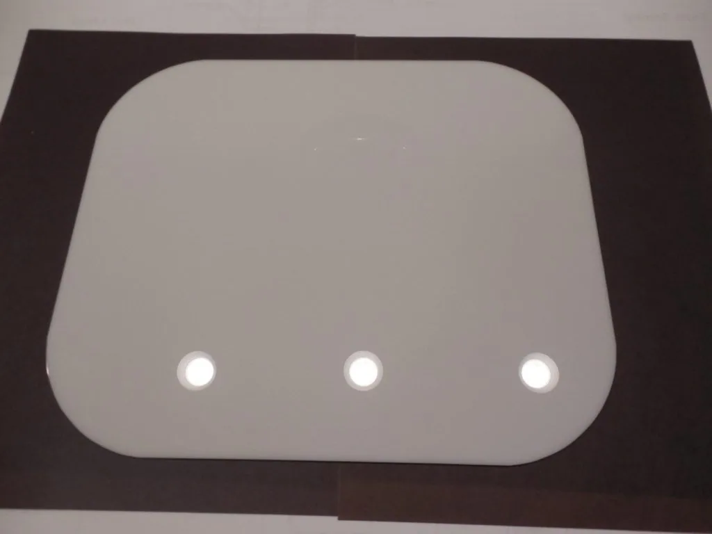 Gray panel with rounded corners mounted in dark brown frame featuring three white circular indicator lights in a horizontal row