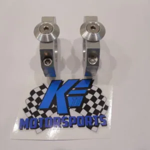 Pair of metallic rocker arm clamps with blue and black K.E. Motorsports branded sticker below