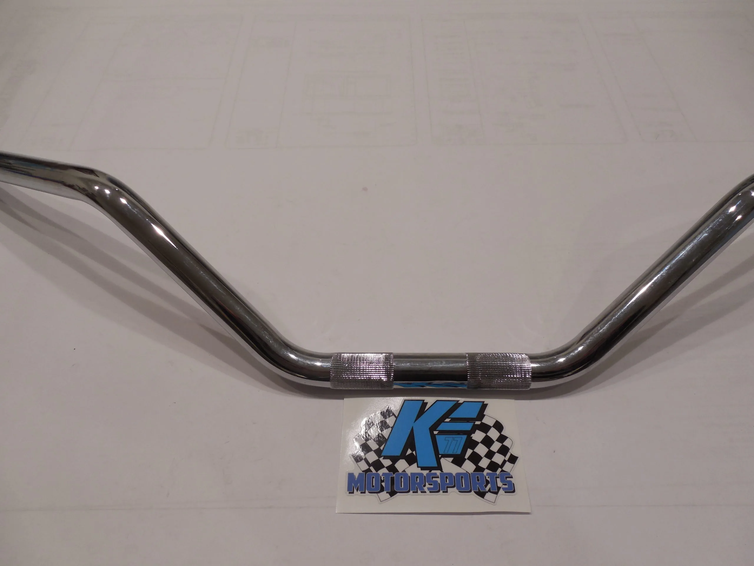 Chrome handlebar with textured grip sections and KF Motorsports logo on white background