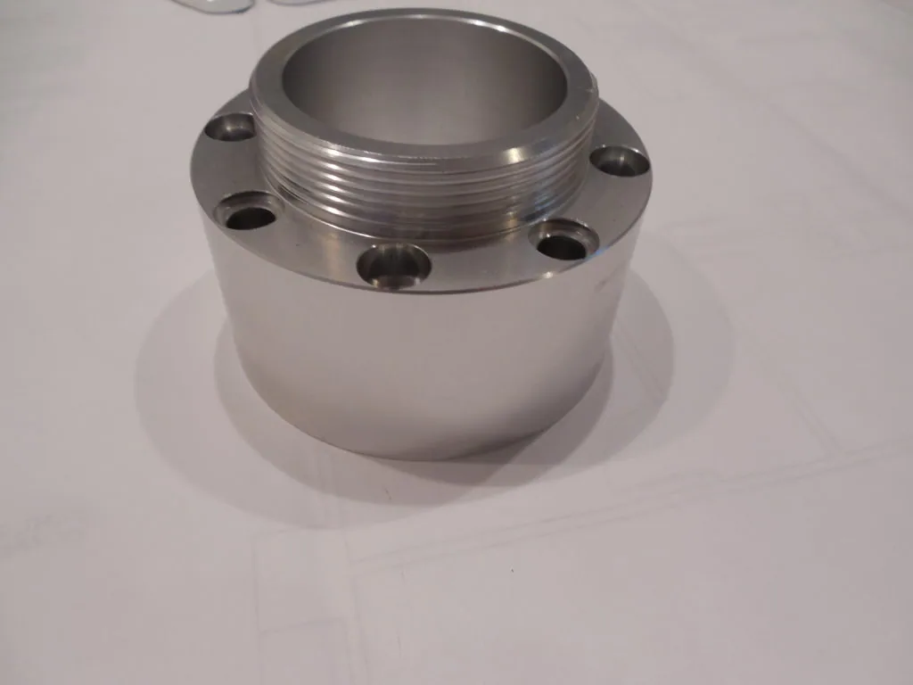Cylindrical metal hub assembly with threaded top ring and four mounting holes on flange
