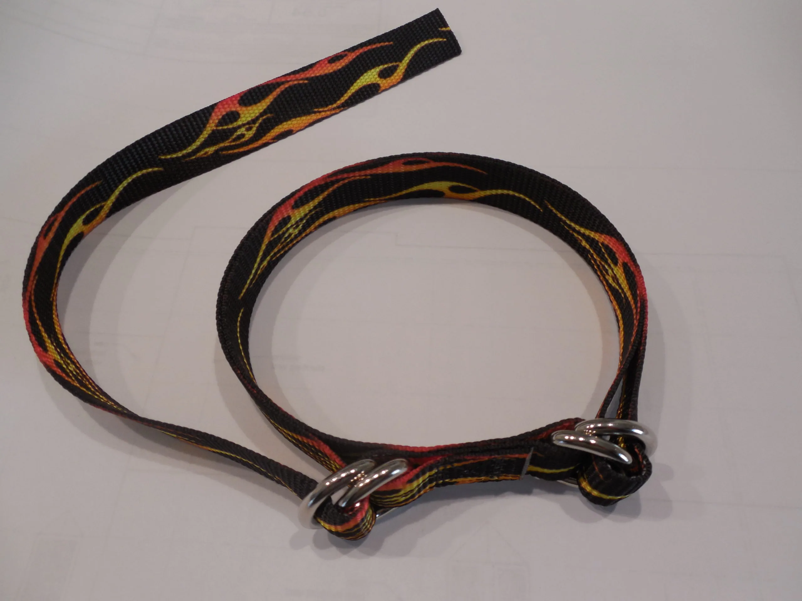 Black dog collar with red and yellow flame pattern design and metal buckle hardware