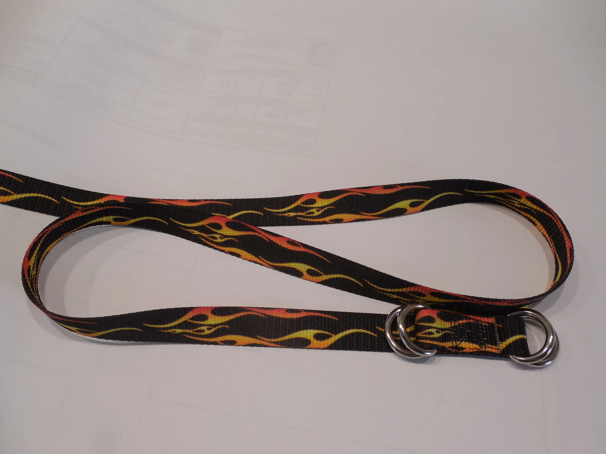 Black nylon leash with red and yellow flame pattern design and metal D-rings on white background