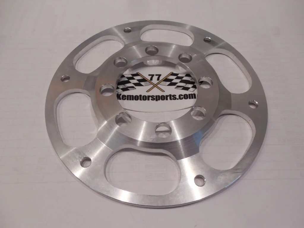 Polished aluminum wheel center cap with checkered flag logo and oval mounting holes