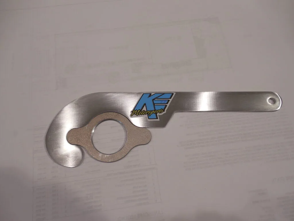 Stainless steel mechanical wrench tool with blue and white logo marking and circular opening