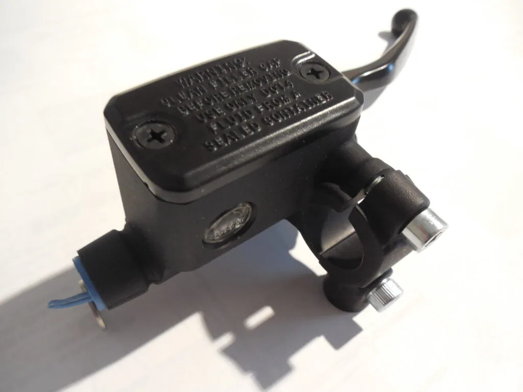 Black motorcycle brake master cylinder with attached lever and blue wire connector
