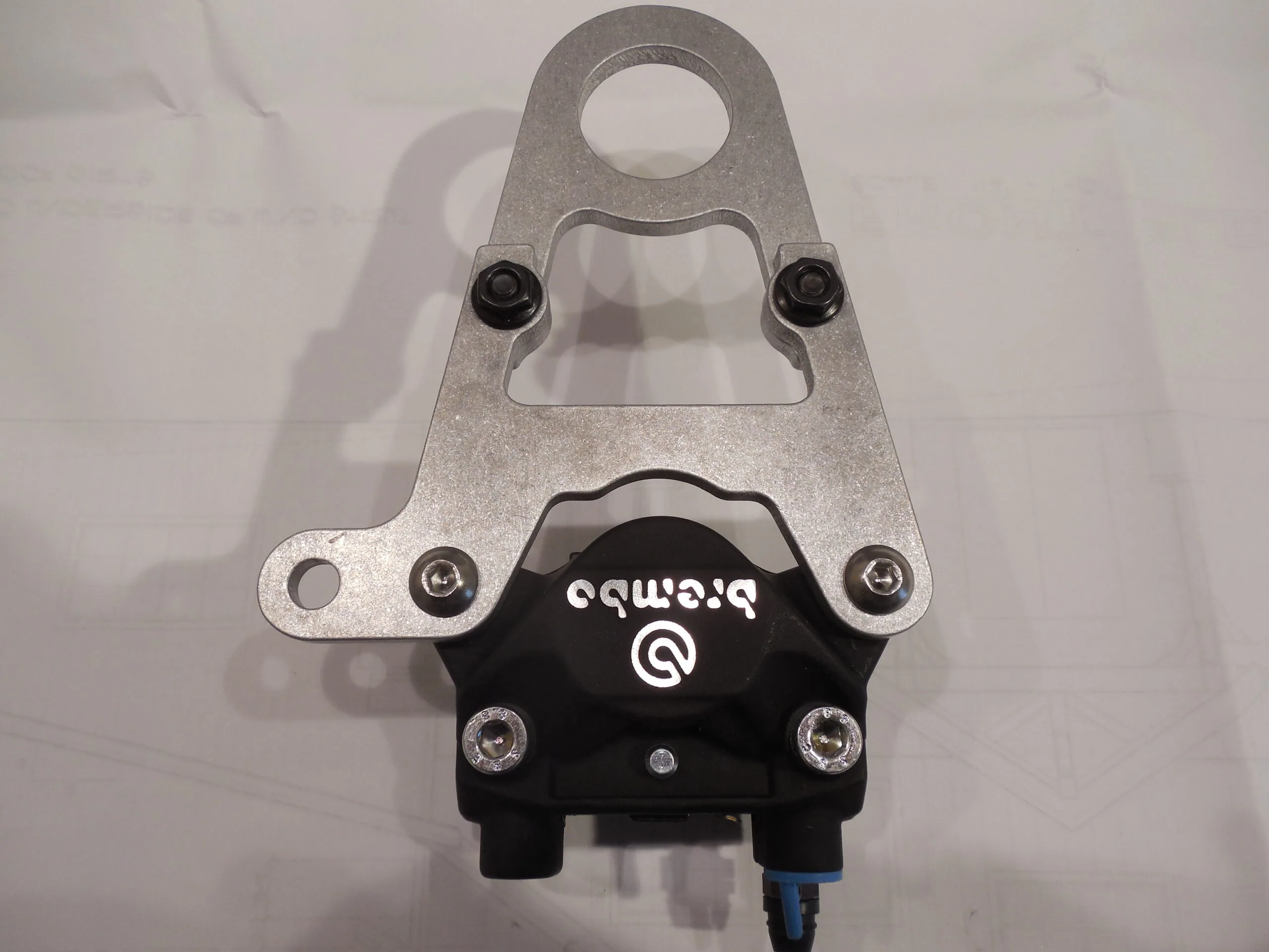 Black and silver bicycle clipless pedal with mounting bracket on white background