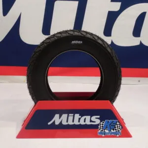 Black Mitas tire displayed on red stand at K. E. Motorsports