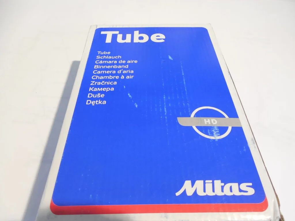 Blue Mitas brand bicycle tube packaging with multilingual text and HD logo on red base